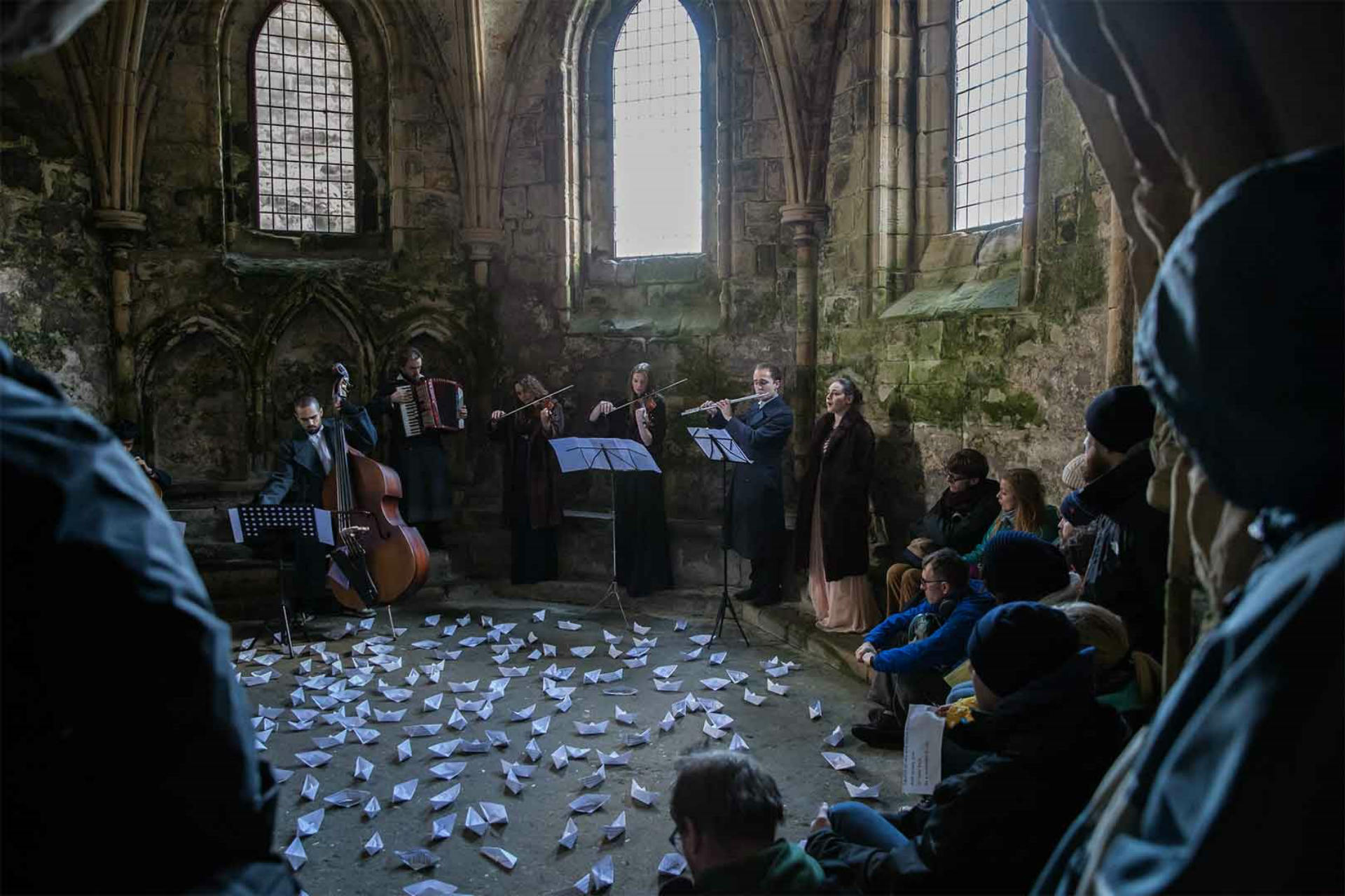 Group of people watching an orchestra playing