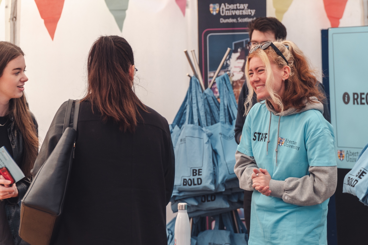 Abertay staff member greeting two guests at an Offer Holder Day