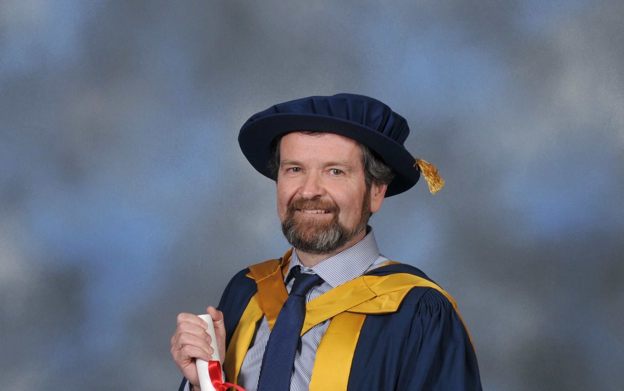 A picture of Michael Lamb holding his honorary degree