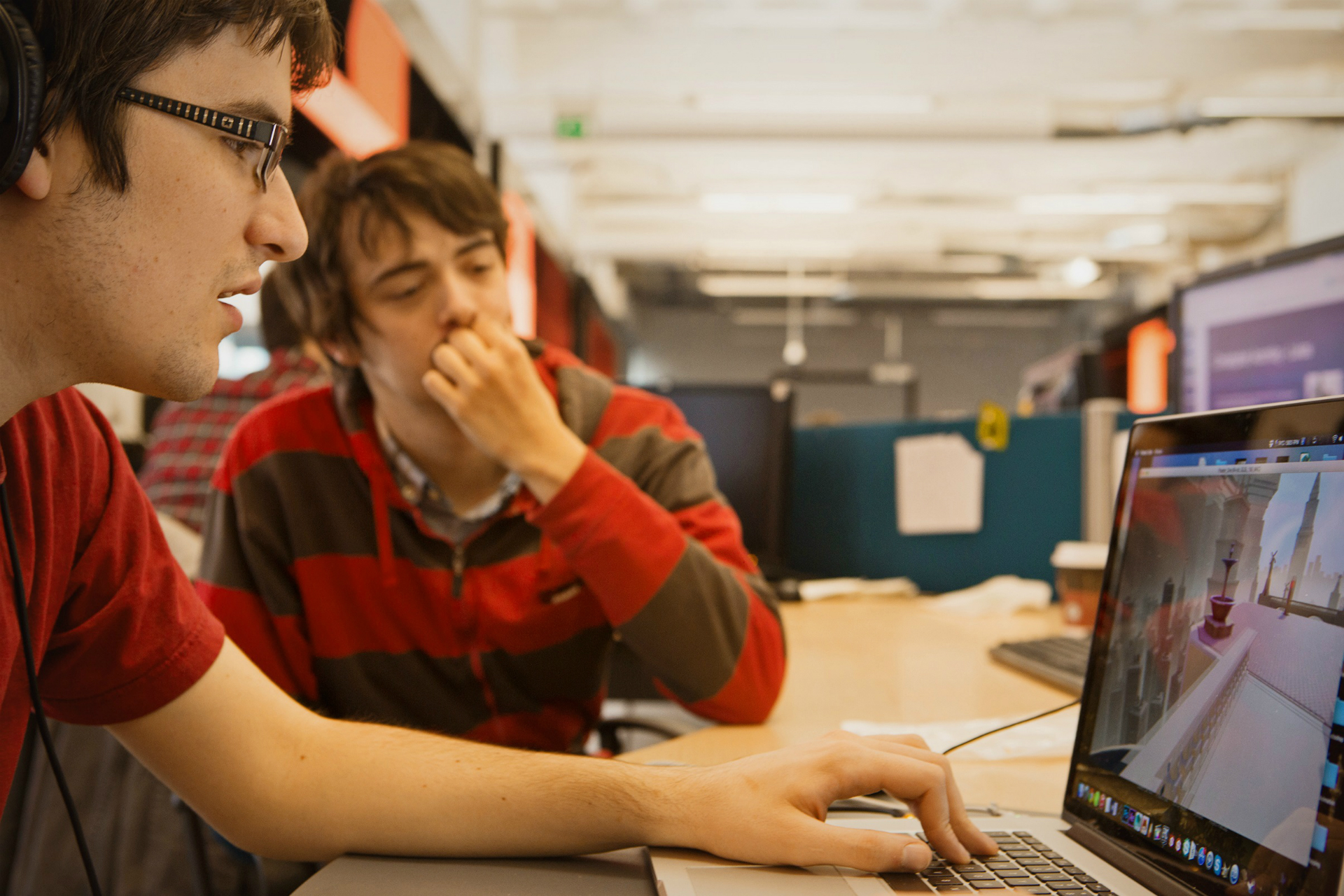 Two students sitting at computer designing a computer game