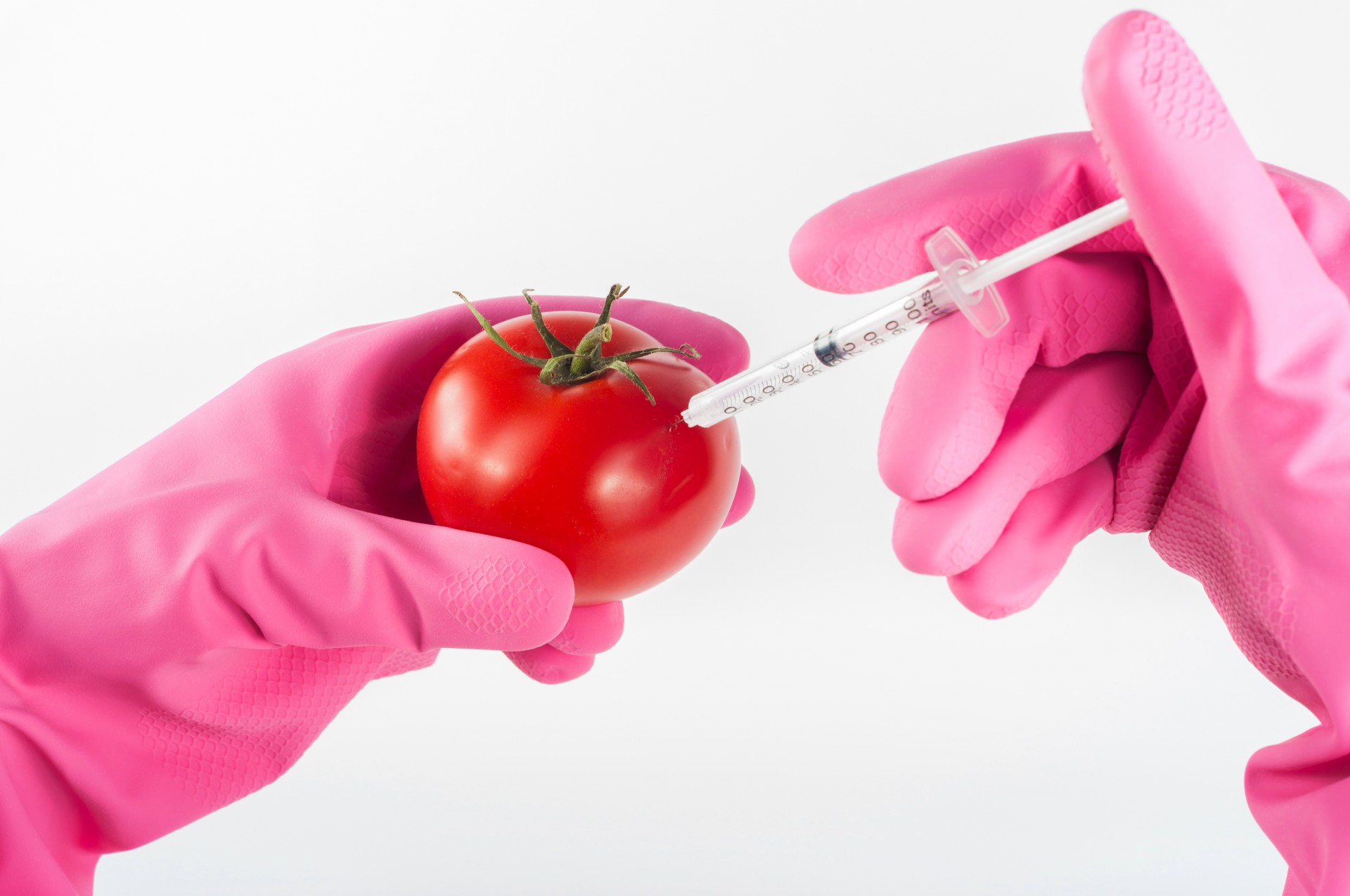 A tomato being injected via syringe 