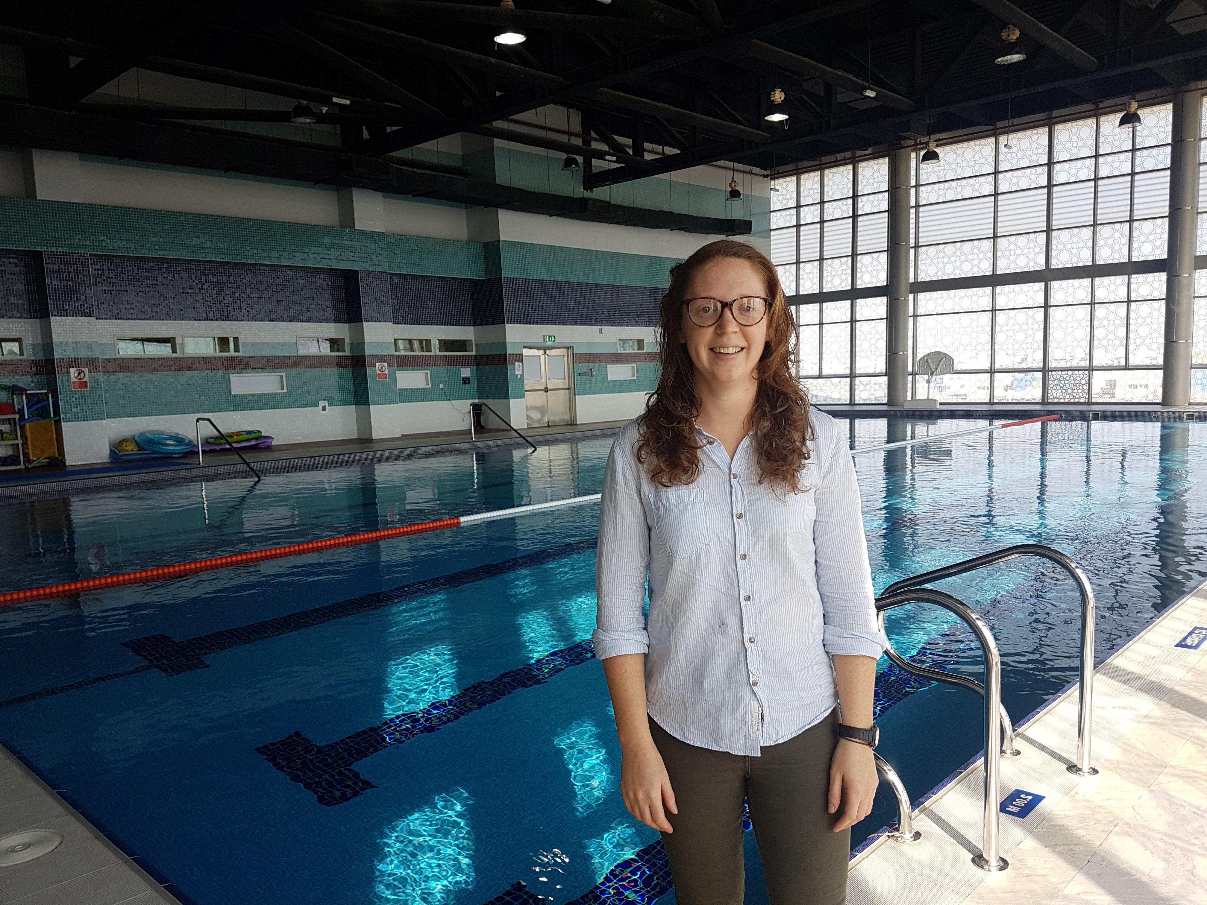 A picture of Alison Chapman standing beside a swimming pool. 