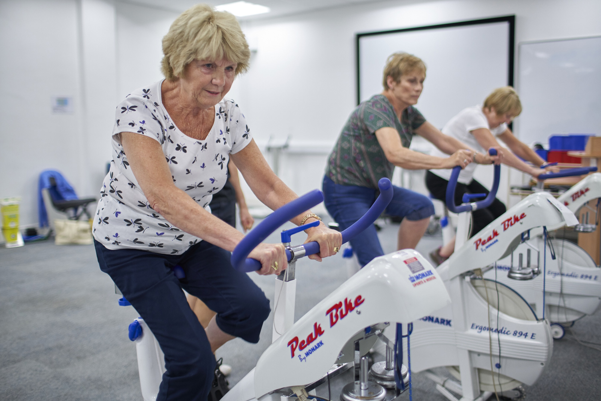A group of three people on exercise bikes